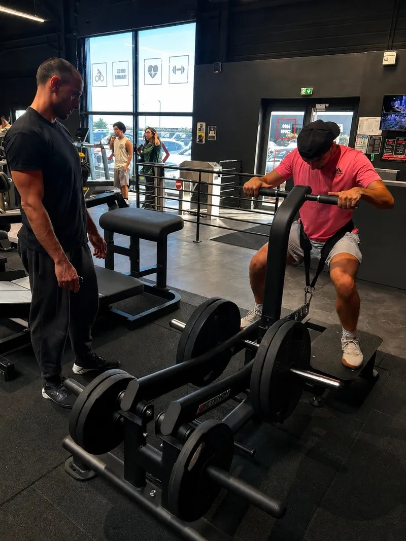 Coach de Fitness Arena accompagnant un adhérent pendant sa séance