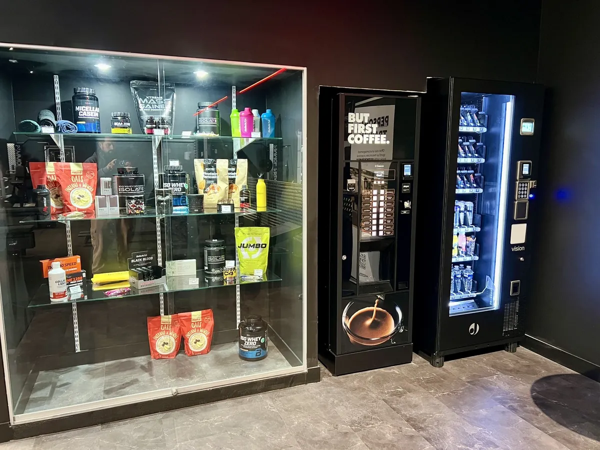 Vitrine de compléments alimentaires et machine à café de l'espace détente Fitness Arena
